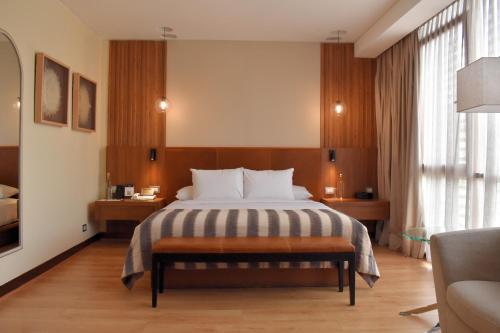 a hotel room with a bed and a large window at NOI Vitacura in Santiago