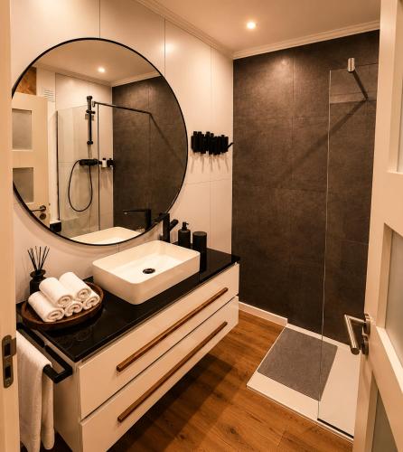 a bathroom with a sink and a mirror at Luxe-Design Imperio II- Petit Déjeuner 5min de la Mer in Praia