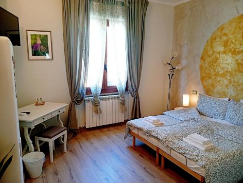 a small bedroom with a bed and a desk at I Mosaici Guesthouse in Ronco Scrivia