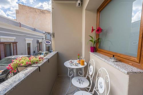 a balcony with a table and chairs and a car at L'Aurora Porto Torres in Porto Torres