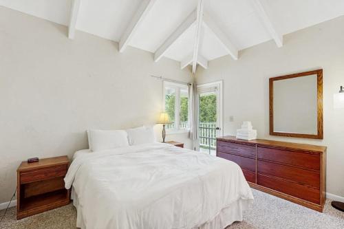 a white bedroom with a large bed and a mirror at Seasons 309 in Warren