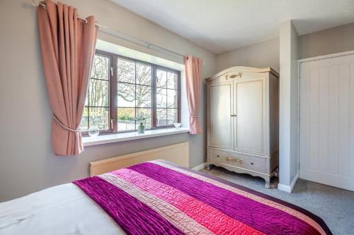 a bedroom with a large bed and a window at 3 Bed in Llanfairpwll oc-22999 in Llanfairpwllgwyngyll