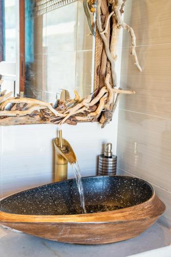 a bathroom with a wooden sink with a water fountain at Lithos House in Avlóna