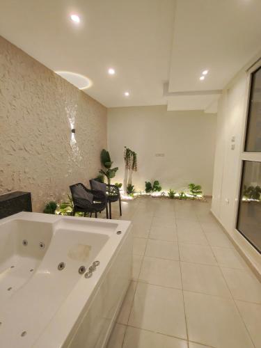 a large bathroom with a tub and chairs in it at Giza Pyramids Hotel in Cairo