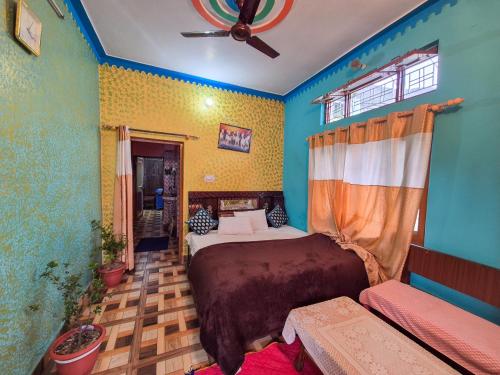 a bedroom with a bed and a ceiling fan at Dev Palace in Uttarkāshi