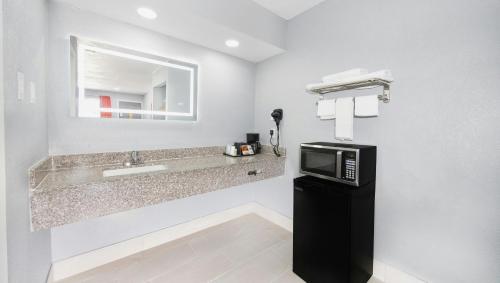 a bathroom with a sink and a microwave at Executive Inn Hondo in Hondo