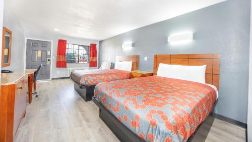 a hotel room with two beds and a kitchen at Executive Inn Hondo in Hondo