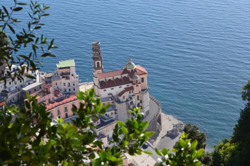 a building on a hill next to the water at Hotel L'Antico Convitto in Amalfi