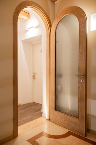 a hallway with a wooden door and a mirror at locazione turistica PetitePomme in Borso del Grappa