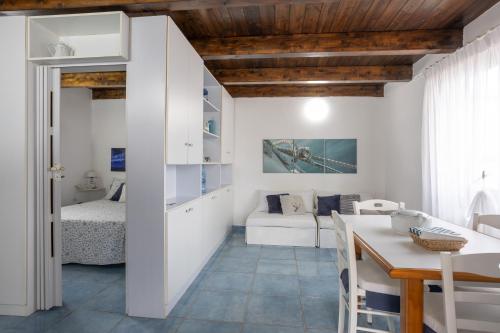 a kitchen and living room with a bed and a table at Villa Giglio Marino in Paestum