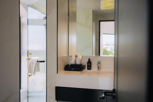 a bathroom with a sink and a mirror at The Manor Hotel in Nam Ðịnh