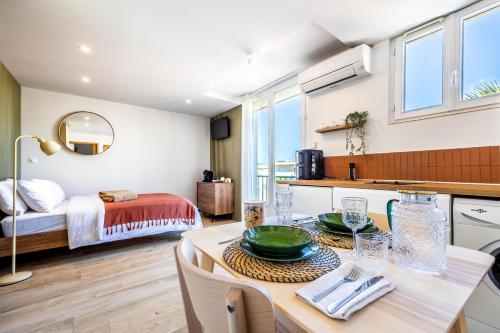 a kitchen and living room with a table and a bed at Studio rénové à Palavas avec accès direct à la plage in Palavas-les-Flots
