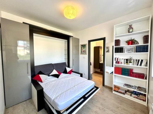 a bedroom with a bed and a book shelf at Le Quai Confort T2 - in Ax-les-Thermes