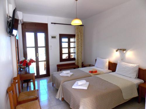 a hotel room with two beds with towels on them at Kato Zakros Palace Apartments in Kato Zakros