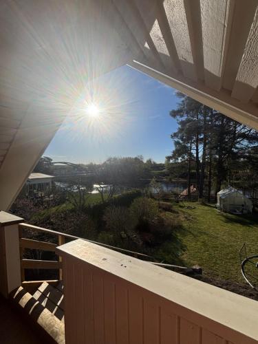 a view from the deck of a house with the sun in the sky at Studio by the river in Forshaga