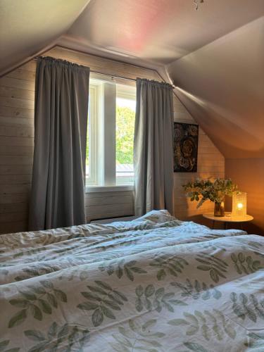 a bedroom with a large bed and a window at Studio by the river in Forshaga