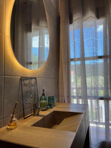 a bathroom with a sink and a mirror and a window at Seaside Athos I in Ouranoupoli