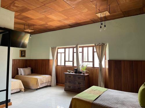 a bedroom with two beds and a window at Hotel Muchá in Quetzaltenango