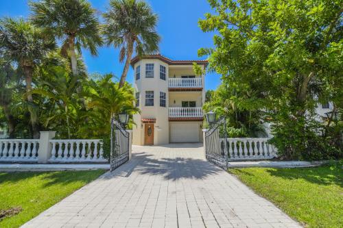 a house with a white fence and palm trees at Villa Florence in Holmes Beach