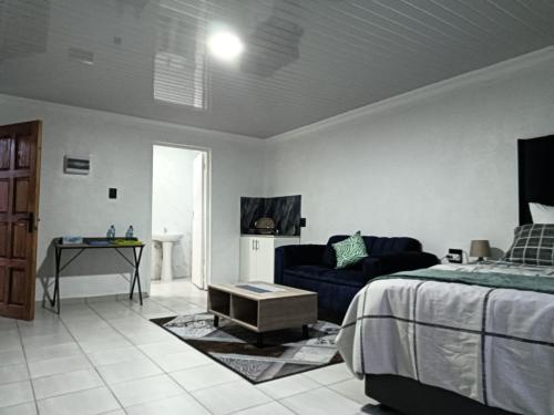 a bedroom with a bed and a couch at Mypeace Comfort in Pretoria