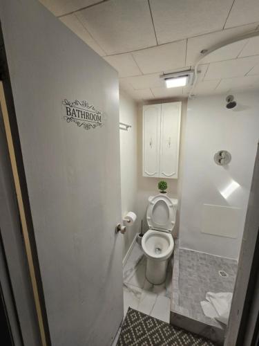 a bathroom with a toilet and a bathroom sign on the wall at Brossard room 3 in Brossard