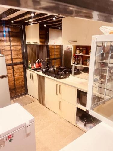 a kitchen with white cabinets and a stove in it at Eightyseven guest and restaurant in Badulla