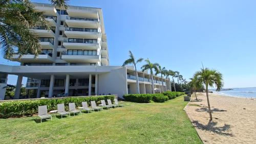 a hotel on the beach with chairs and palm trees at Zantamar Riviera Nayarit at La Cruz de Huanacaxtle in Cruz de Huanacaxtle