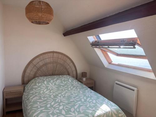 a small bedroom with a bed and a window at Le face mer in Le Portel