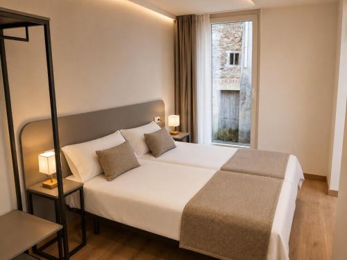 a bedroom with a large bed and a window at Pensión O Novo in Treacastela