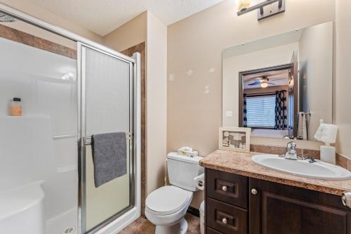 a bathroom with a toilet and a sink and a shower at Executive 5 bdrm 3 ba House in Bonnyville