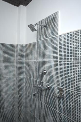 a bathroom with a shower with black and white tiles at Nagarkot Zip Coaster Pvt Ltd in Nagarkot