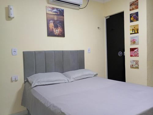 a bedroom with a large bed with a white bedspread at Capim de Ouro Flats Mobiliados in Palmas
