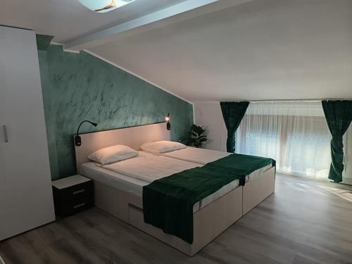 a bedroom with a large bed with a green blanket at Proprietate privata in Lazu