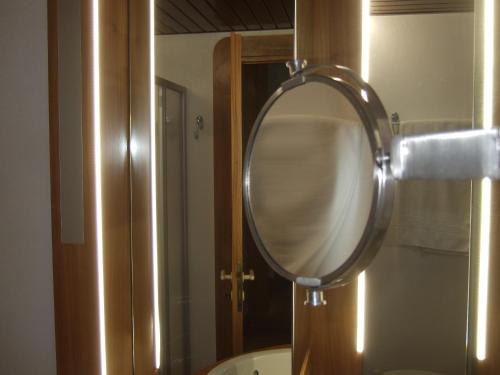 a bathroom with a round mirror on a wall at Hotel Canturio in Cantù