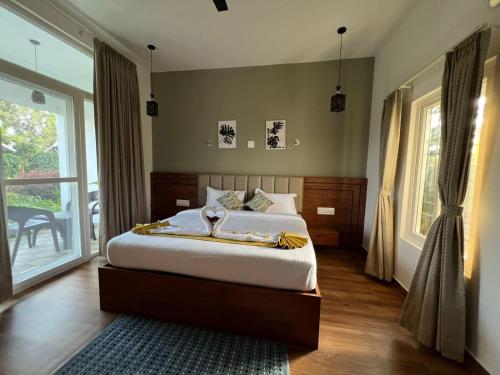 a bedroom with a bed and a large window at The Fox Resort, Bandipur in Bandipūr