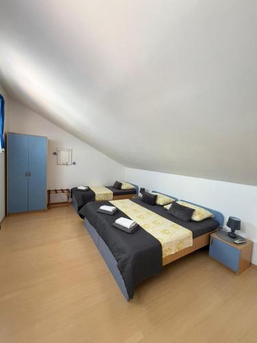 a bedroom with two beds and a white wall at Villa Kale Apartments in Slatine