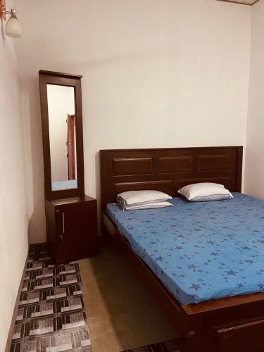 a bedroom with a bed and a mirror at KR Villa in Arugam Bay
