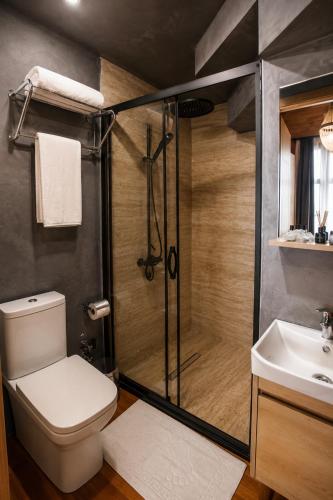 a bathroom with a shower and a toilet and a sink at City Bungalow Hotel in Edirne