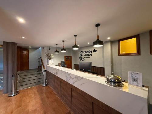 a lobby with a counter with a sign on the wall at Conde de Lemos Hotel in Puno