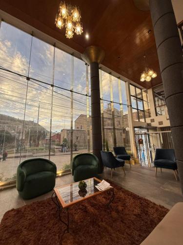 a lobby with a large window with chairs and a table at Conde de Lemos Hotel in Puno