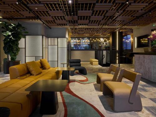 a lobby with a couch and a table and chairs at TRIBE Belo Horizonte Savassi in Belo Horizonte