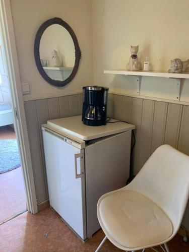 a kitchen with a small refrigerator and a chair at Örkelljunga cottage in Orkelljunga