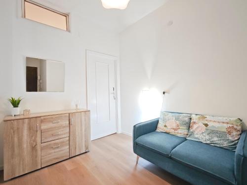 a living room with a blue couch and a dresser at Dimora Leccese in Lecce