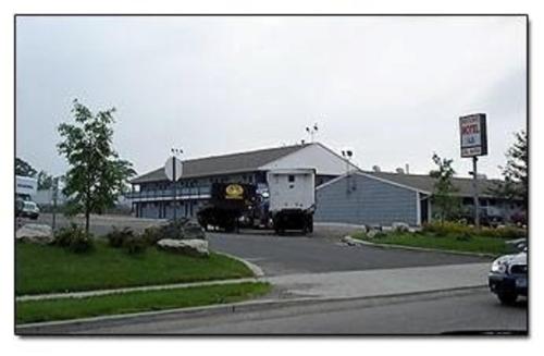 a white truck parked in front of a building at Mayflower Motel Milford in Milford