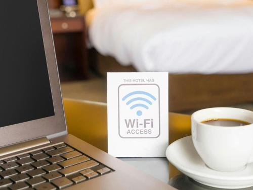 a laptop computer and a cup of coffee on a table at Mayflower Motel Milford in Milford