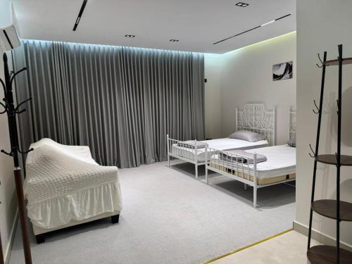 a hospital room with two beds and curtains at شاليه مرزوقة in Buraydah