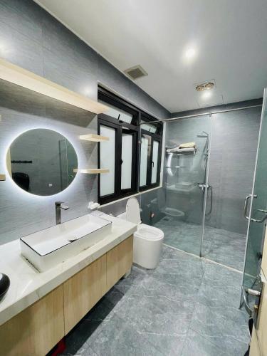 a bathroom with a toilet and a sink and a shower at Đông Hương Home in Cat Ba
