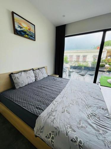 a bedroom with a bed and a large window at Đông Hương Home in Cat Ba
