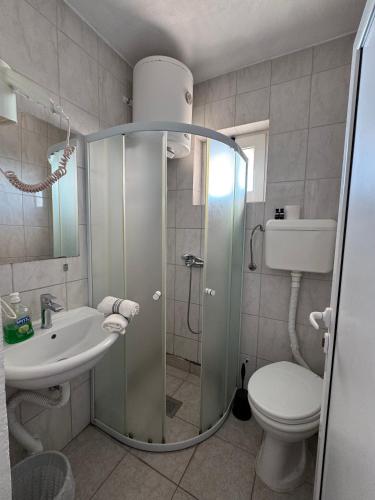 a bathroom with a shower and a toilet and a sink at Apartments Adriatik in Ulcinj