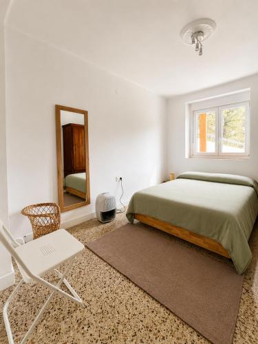 a bedroom with a bed and a mirror and a chair at Fantastico retiro rural en el corazon de Euskadi in Elgóibar